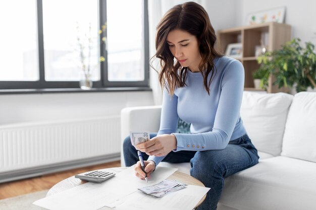 A person using a calculator while reviewing mortgage documents, illustrating the importance of careful financial assessment.