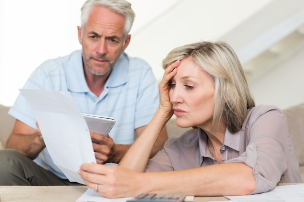 A split image showing two families - one appearing stressed while looking at tax forms (labeled 
