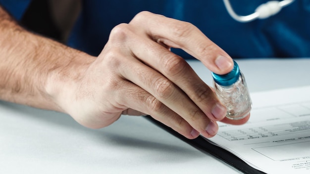 A close-up shot of a hand filling out a healthcare application form with a pen. A calculator and a document titled 
