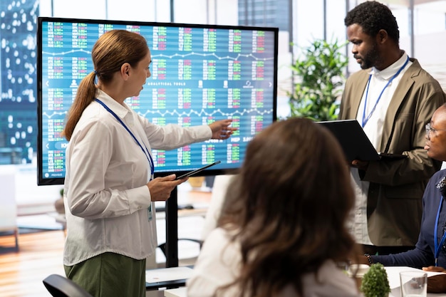 A diverse group of people collaborating around a large screen displaying data visualizations and charts, signifying the importance of data literacy and teamwork.