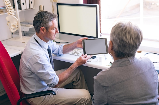 A veteran working with a VR&E counselor in an office setting, reviewing career options and discussing educational paths. The counselor is pointing at a computer screen displaying job opportunities.
