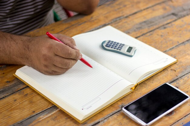 A close-up shot of a hand filling out a tax form with a calculator and a pen, highlighting the process of claiming the EITC.